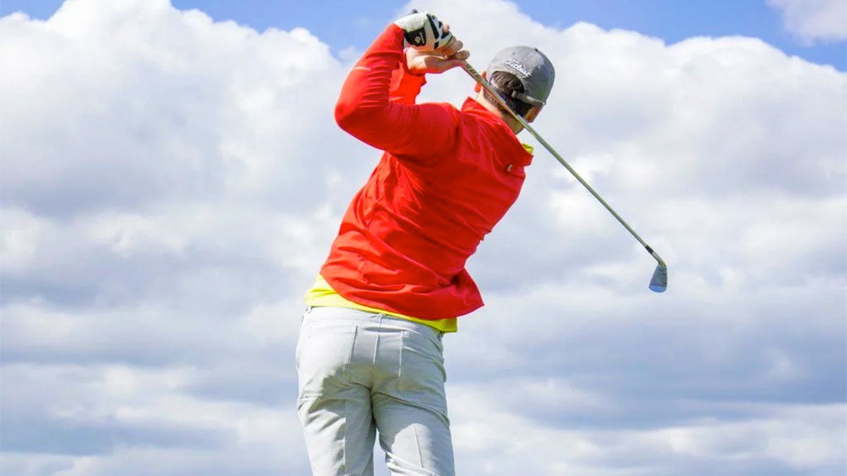 man teeing off at golf course on cloudy day